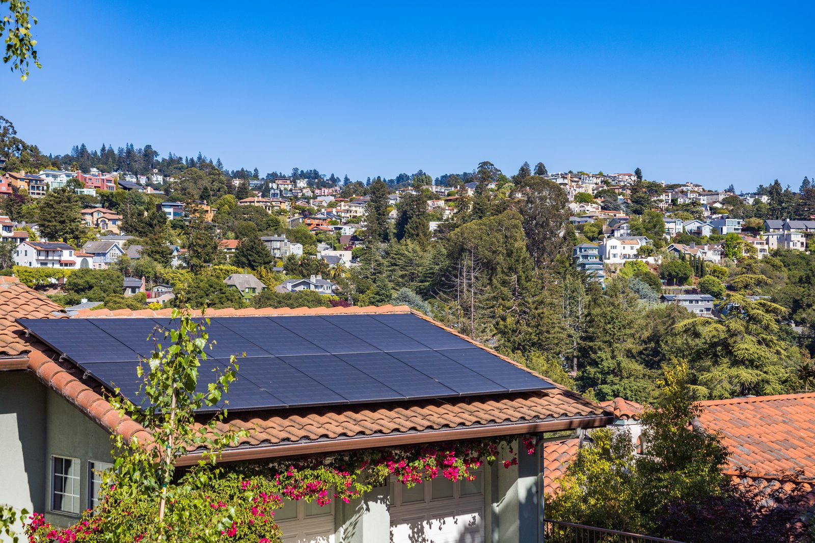Solar panels installed on a domestic pitched roof under a clear sky